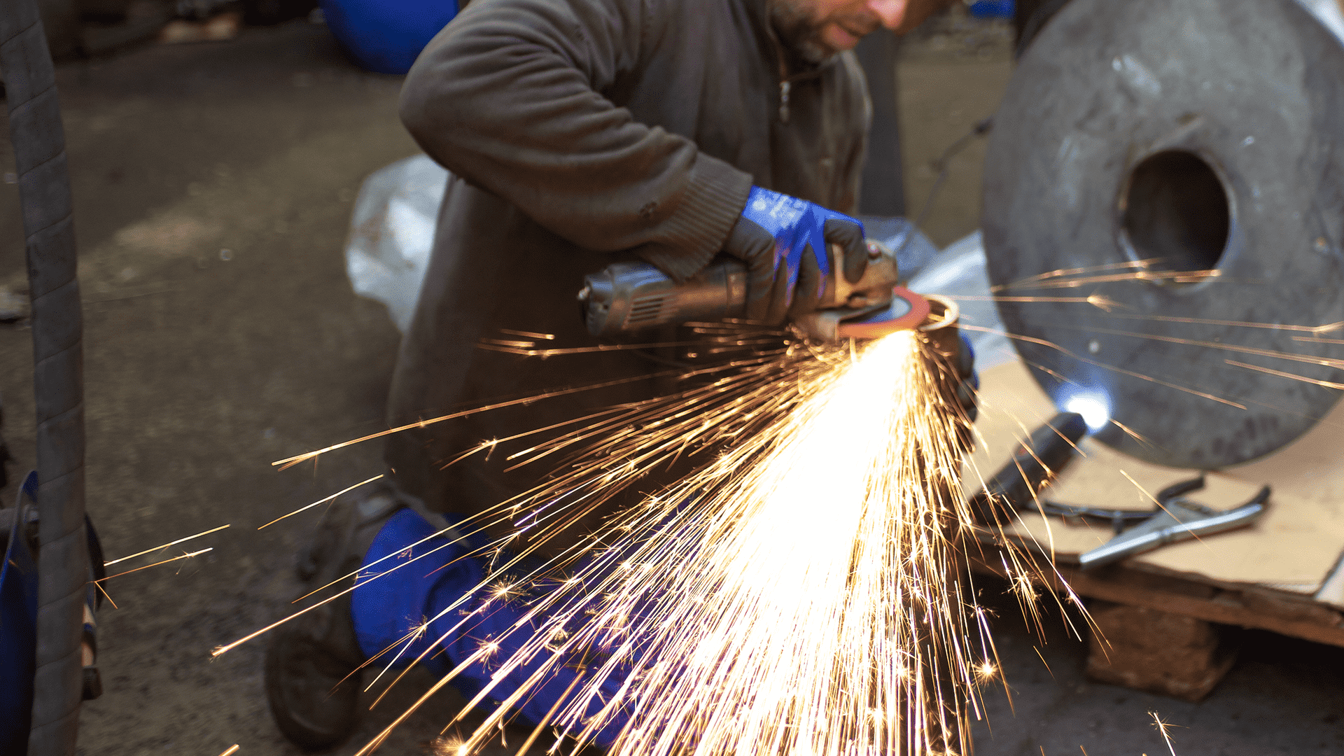 Photo du making of du telescope, ici un ouvrier utilise une disqueuse