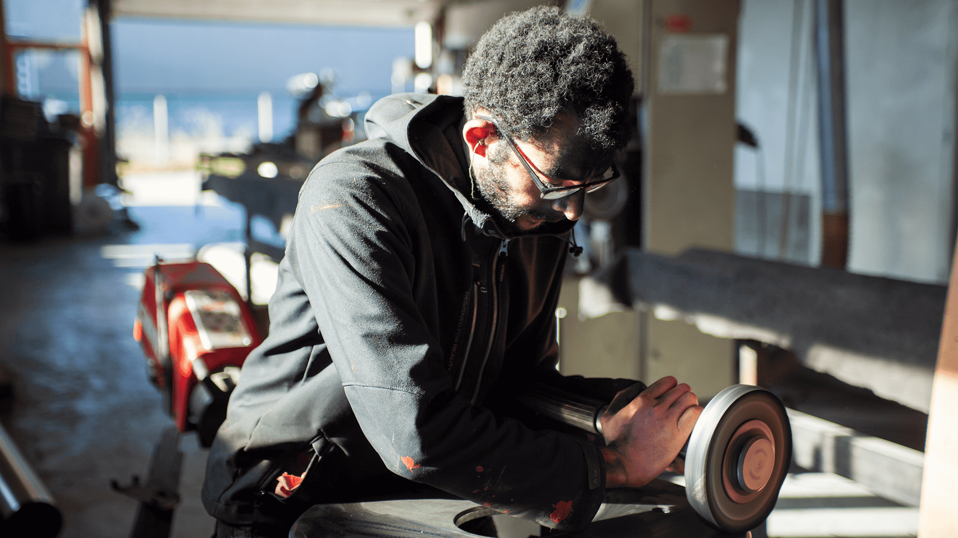 Photo du making of du telescope, ici un ouvrier semble poncer ou polir une pièce en métal